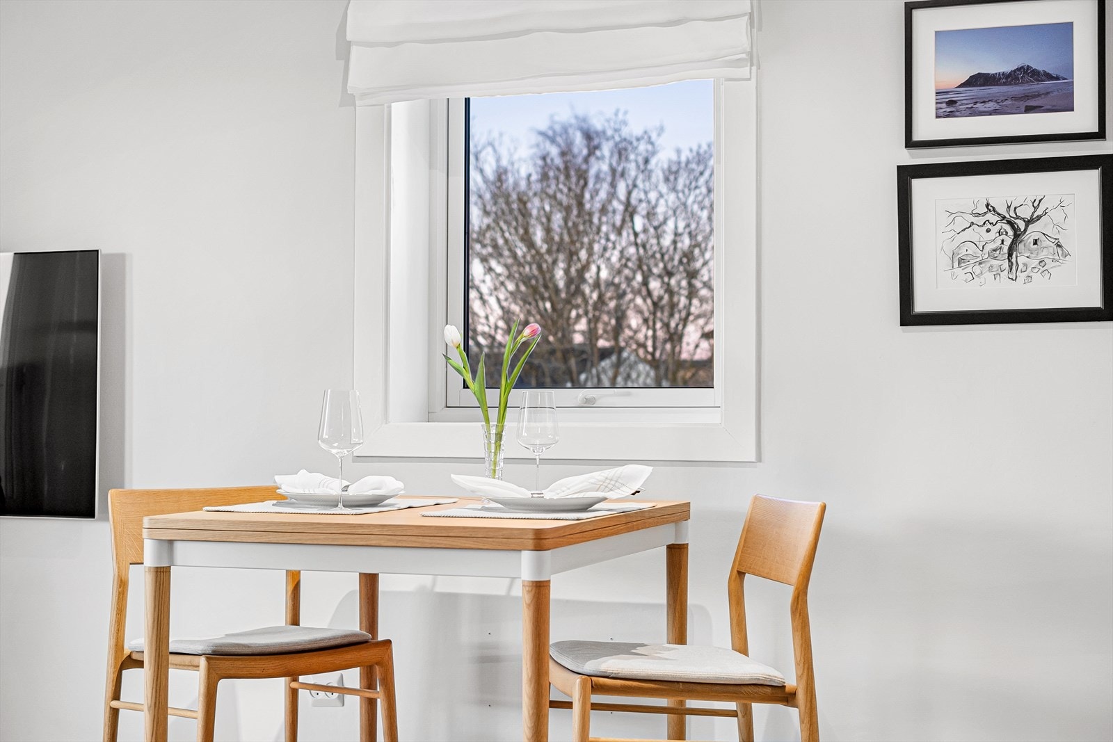 Spisebordet er plassert ved et vindu med utsikt mot grønne omgivelser. Vinduer byttet omkring 1998 i regi av borettslaget. Galleribilde