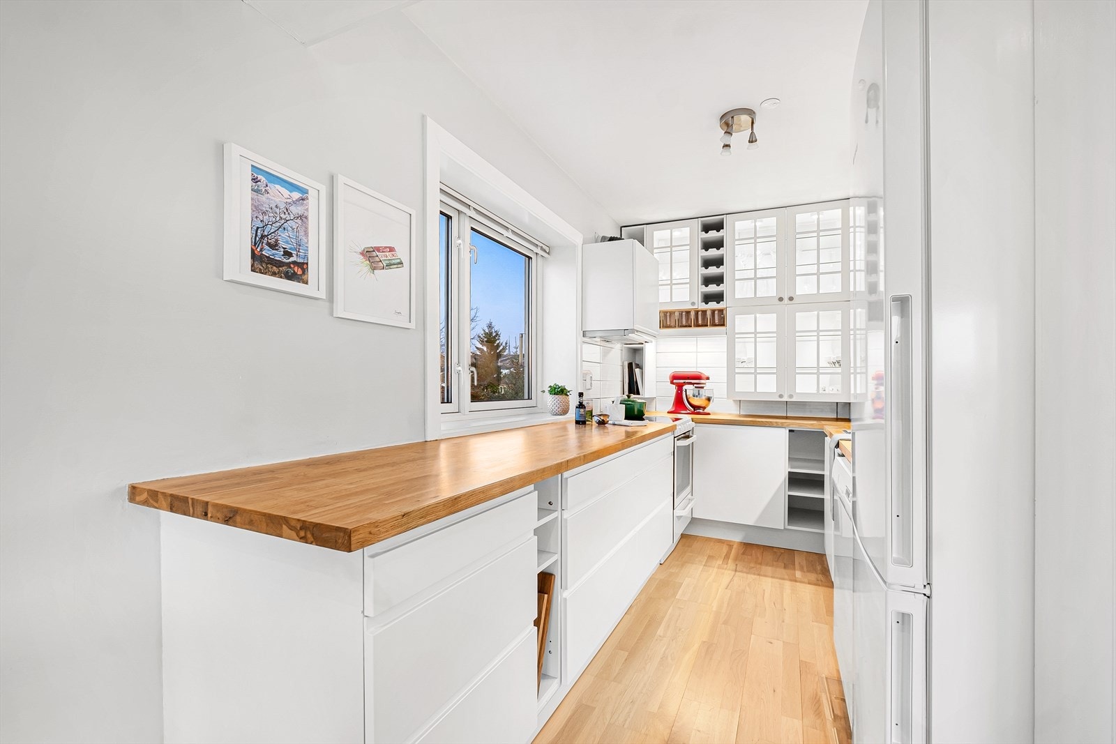 Kjøkkenet har takhøye overskap med glassdører for ekstra oppbevaring. Galleribilde