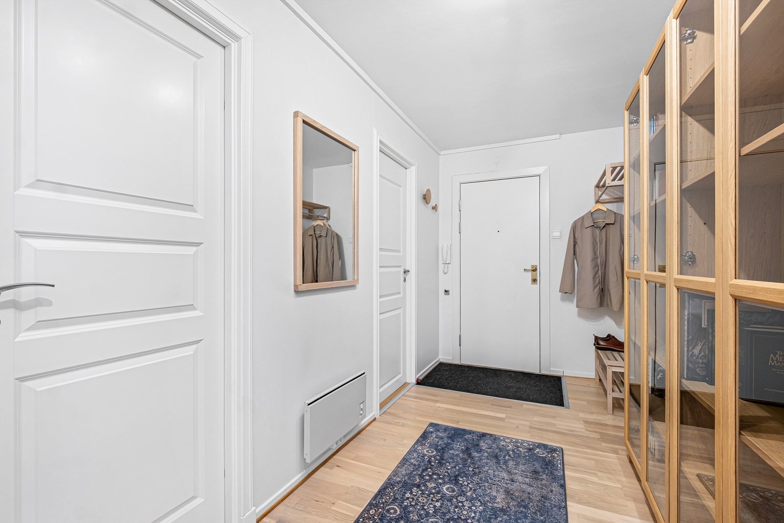 Entréen har parkettgulv og hvite dører som gir et rent uttrykk. Galleribilde