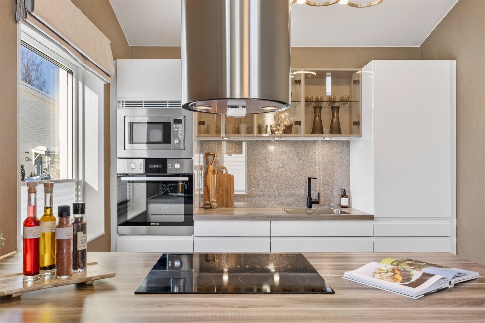 Kjøkkenet har induksjonsplatetopp, underlimt vask og mekanisk kjøkkenventilator. Galleribilde