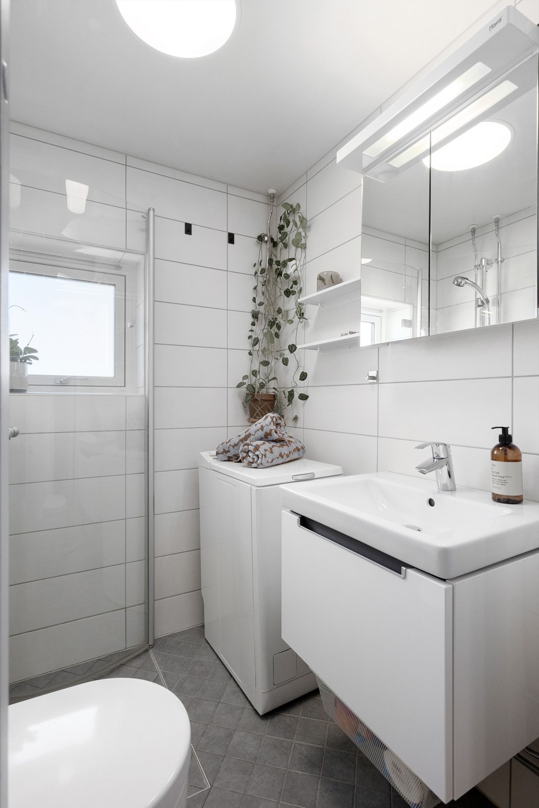 Flislagt bad med moderne uttrykk og gjennomtenkt plassering av innredning - effektiv bruk av arealet. Galleribilde