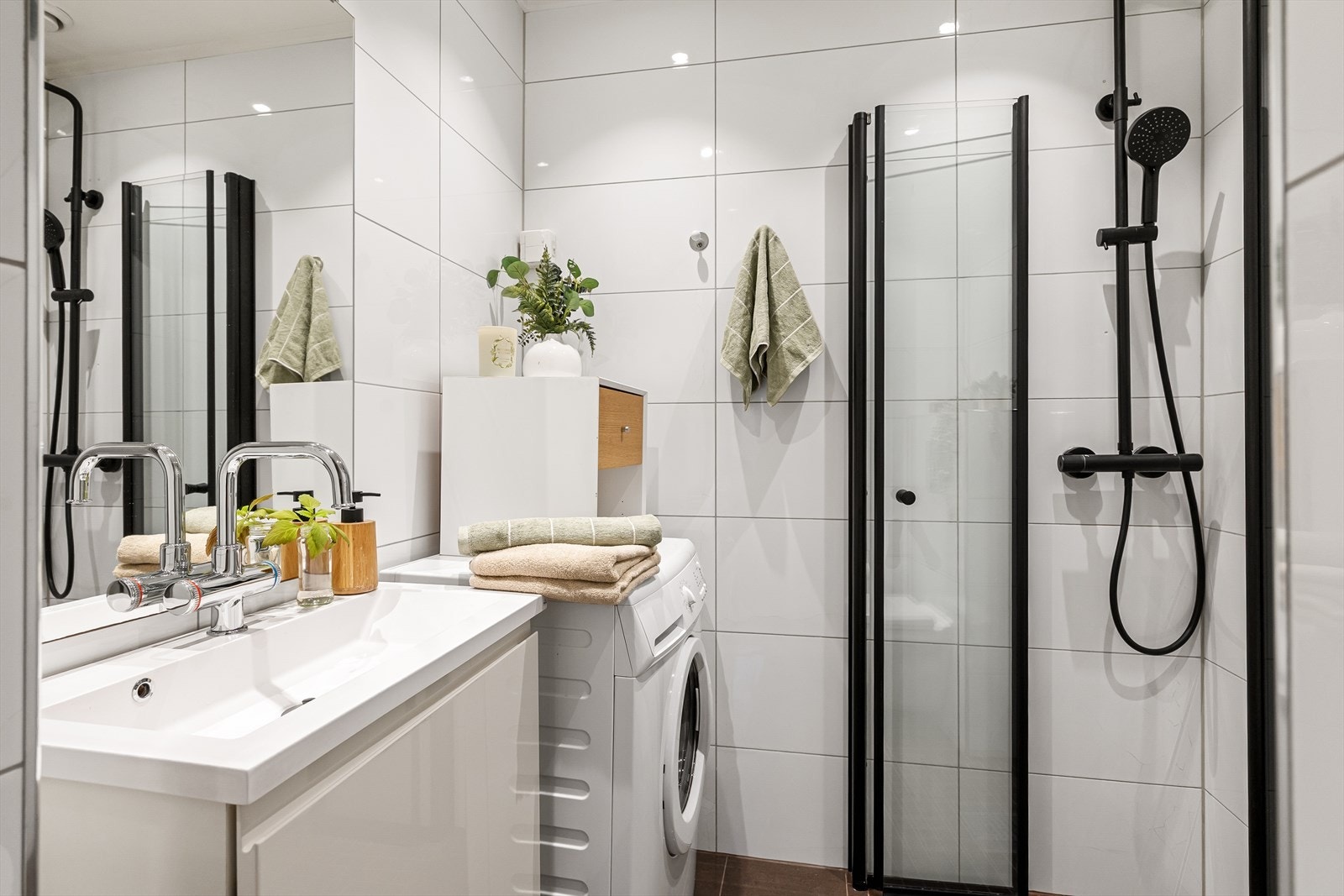 Pent, flislagt baderom med downlights i himlingen og gulvvarme. Eldre dusjkabinett ble skiftet ut og nye glassdører ble montert i oktober 2025. Galleribilde