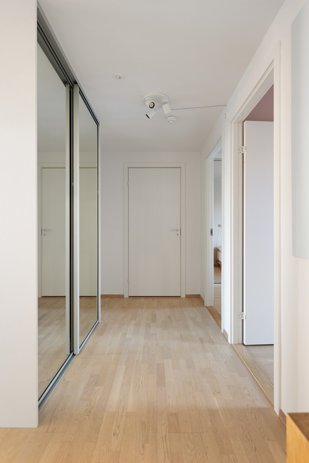 Den store entreen byr på skyvedørsgarderobe med glassfronter for oppbevaring av sko og yttertøy Galleribilde