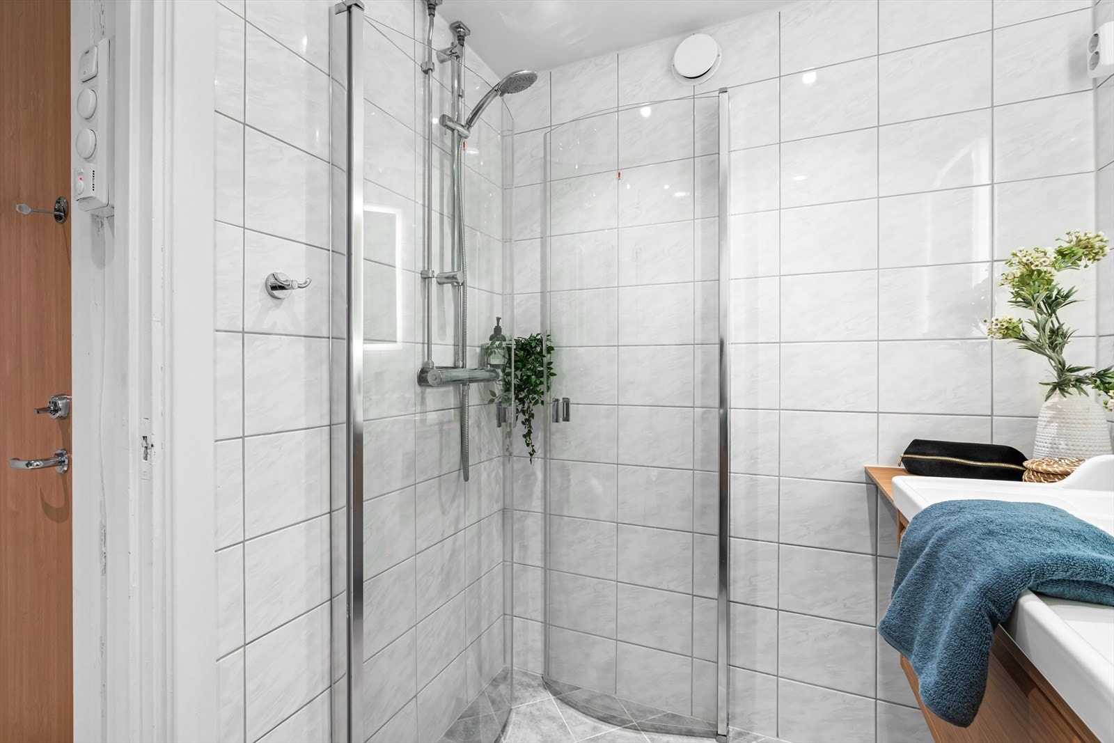 Rommet er innredet med vegghengt toalett, dusjhjørne og speil med integrert belysning. Justerbare dusjdører er satt inn for å utnytte plassen maksimalt. Galleribilde