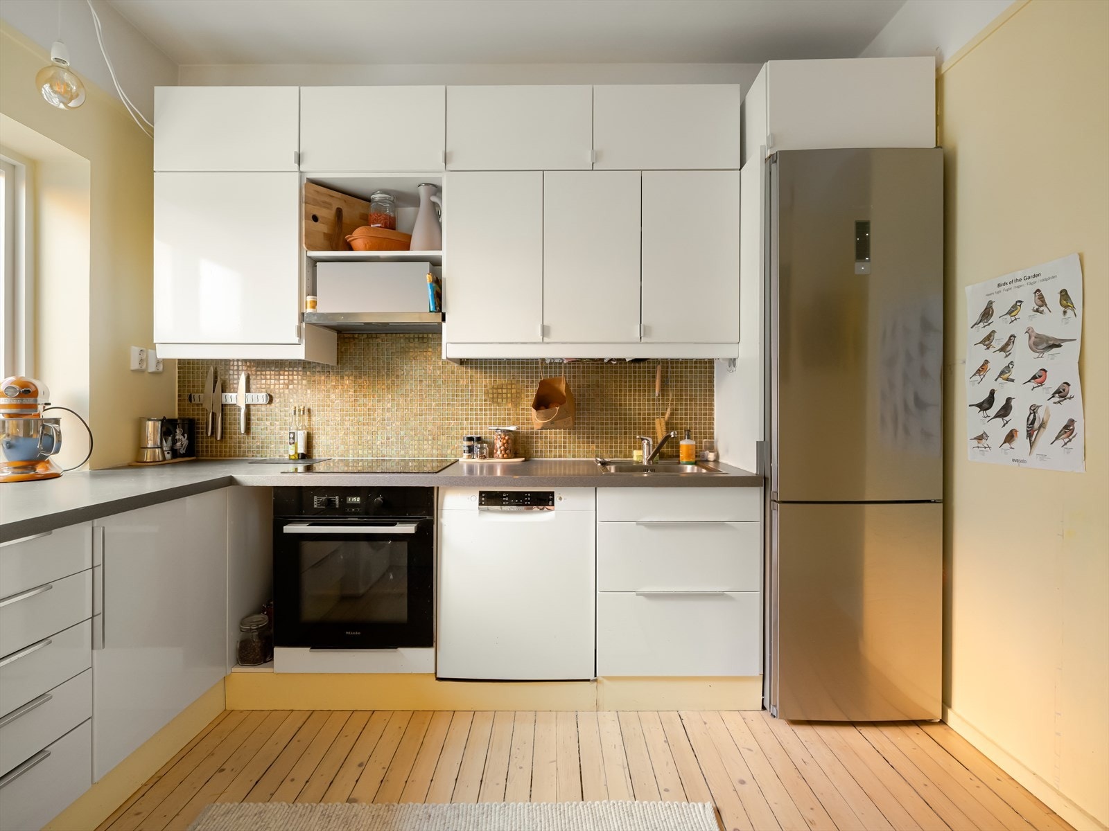 Innredningen har over og underskap, laminert benkeplate med nedfelt vask, mekanisk ventilator og platetopp. Galleribilde