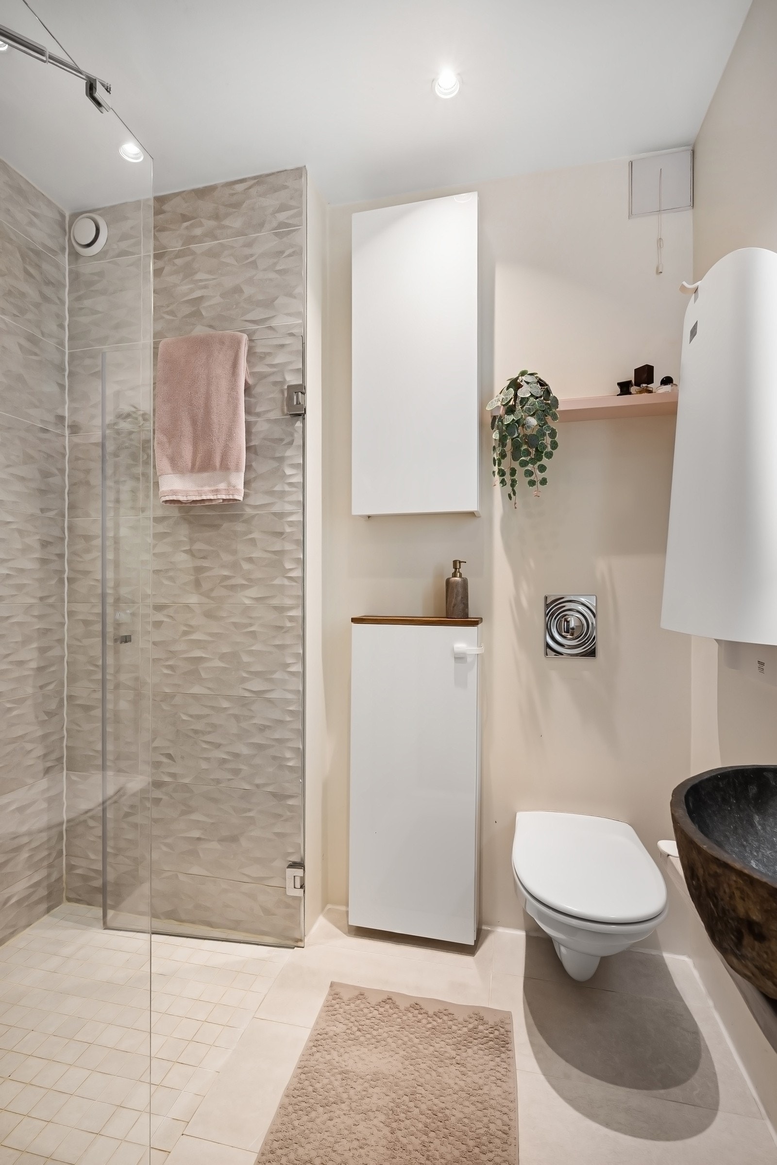 Rommet er innredet med servant i stein med ettgrepsarmatur fra Tapwell, speil med integrert belysning, veggmontert toalett, dusjnisje med innfellbare dusjdører. Galleribilde