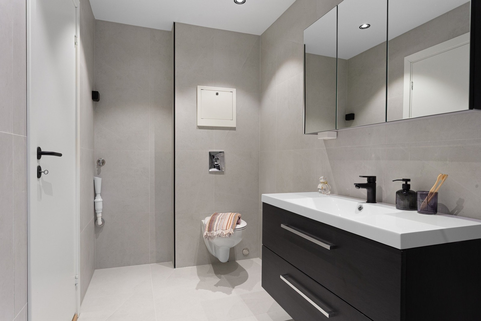 Badet har en moderne sort innredning og gjennomførte sorte detaljer som skaper et fint helhetsinntrykk Galleribilde