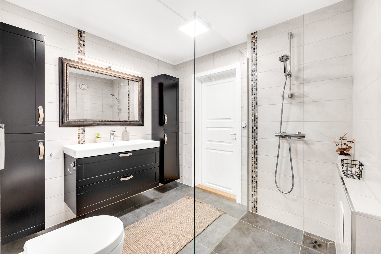 Badet er gjennomgående preget av moderne design og friske detaljer, som sammen skaper en lys og innbydende atmosfære med fokus på både funksjonalitet og estetikk. Galleribilde