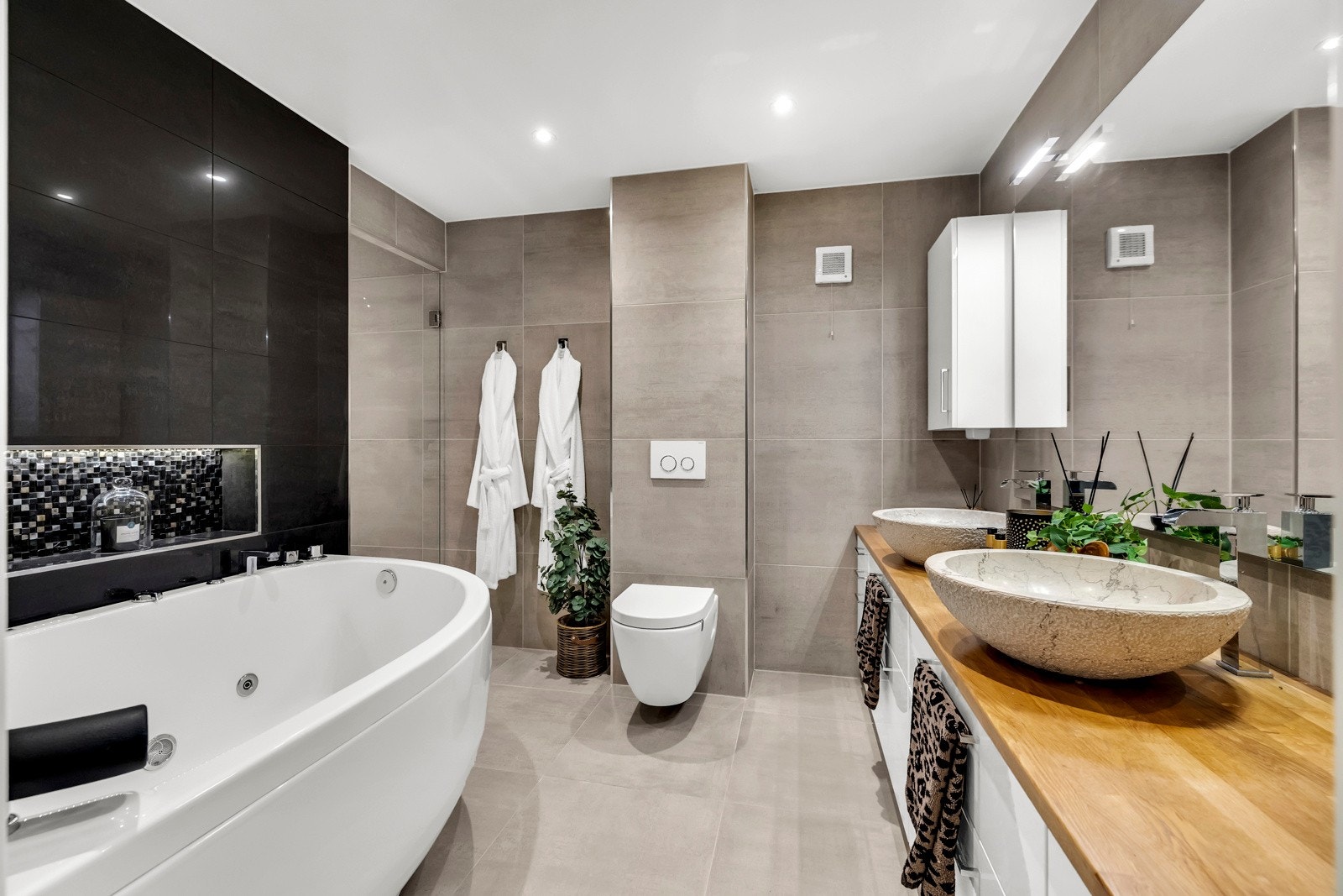 Badet, som ble pusset opp i 2016, fremstår som svært innbydende, med store beige-grå fliser som gir et tidløst og eksklusivt uttrykk. Galleribilde