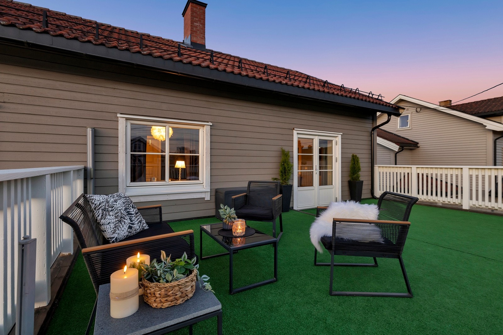 Terrassen med utgang fra stuen i 2.etasje på kveldstid. Galleribilde
