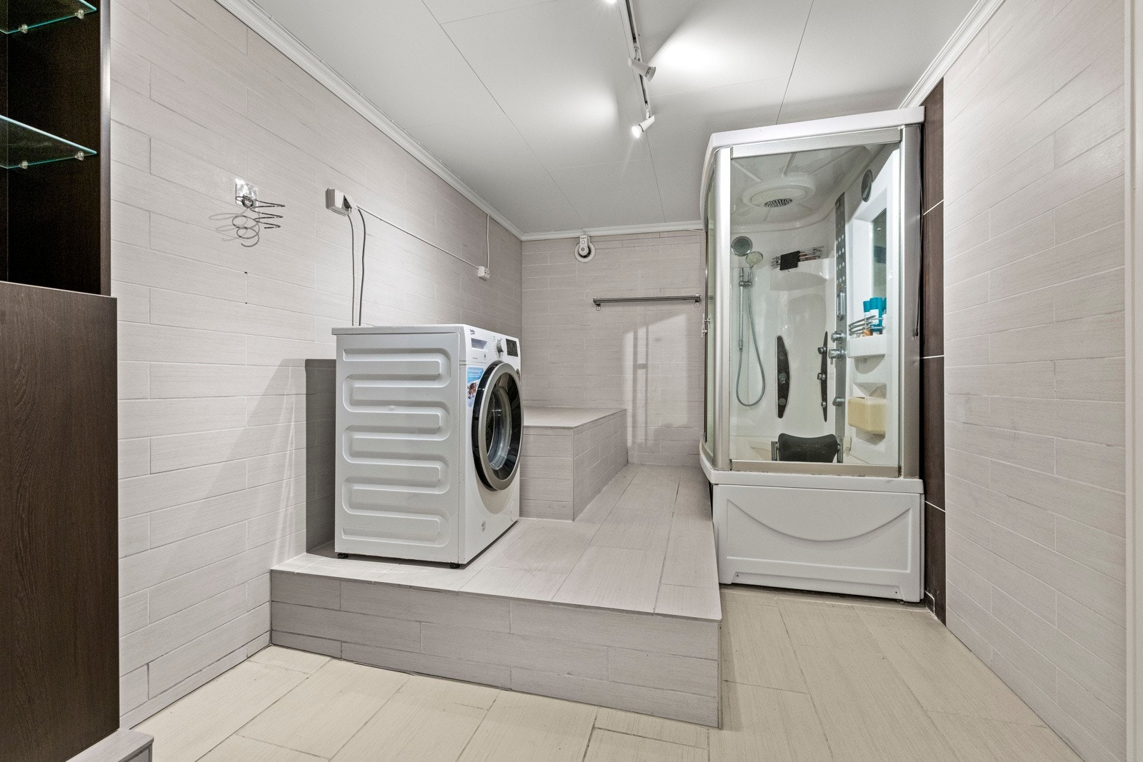 Det er praktisk opplegg for vaskemaskin og et stort badekar med kabinett. Galleribilde