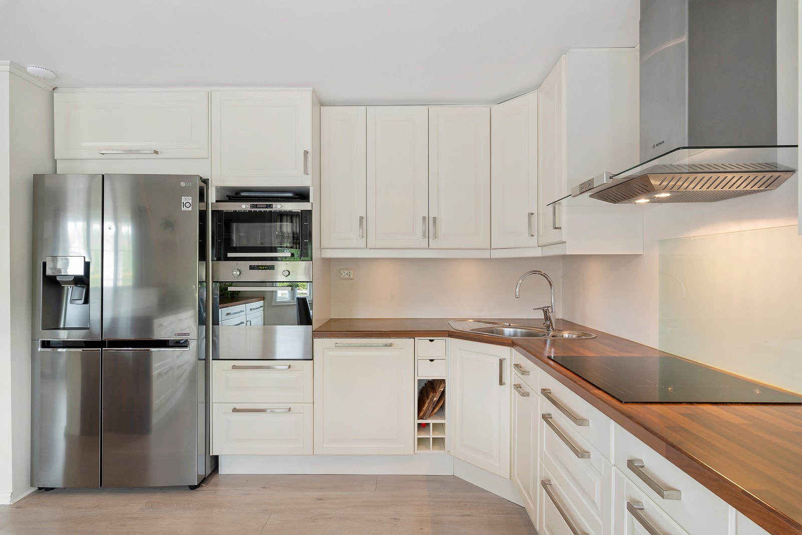 Det er integrert stekeovn, mikrobølgeovn og oppvaskmaskin, nedfelt koketopp og plass til side om side-kjøleskap Galleribilde