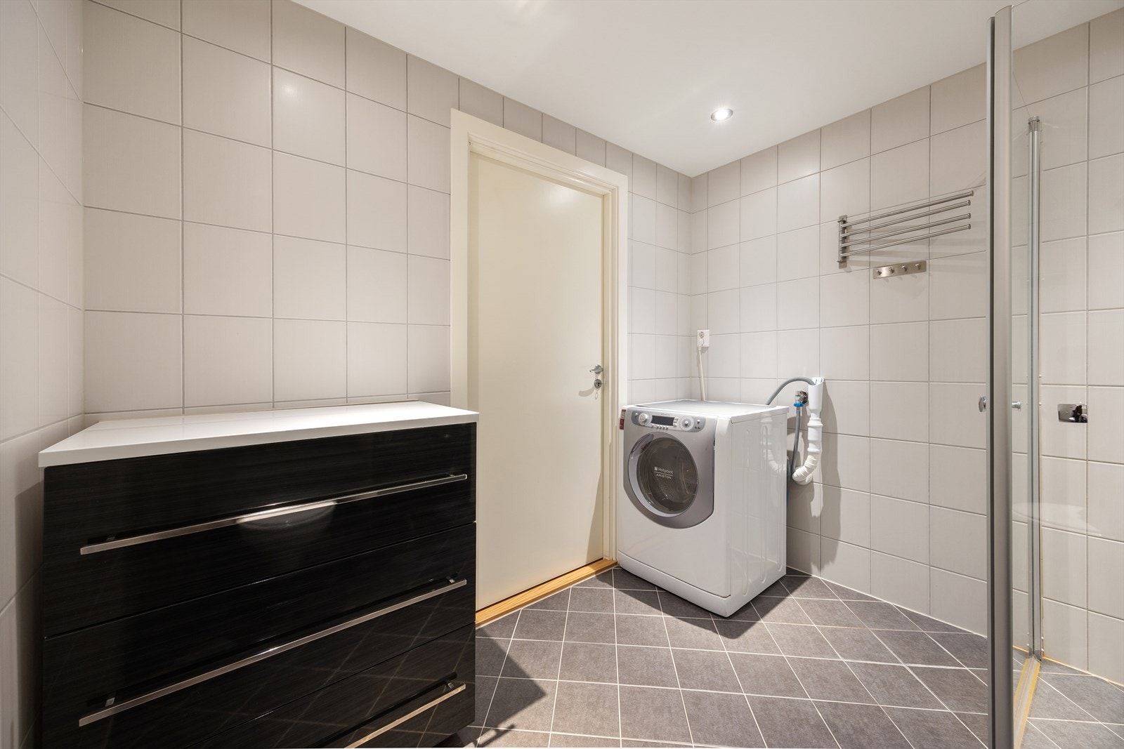 Innredningen består av flislagte gulv/vegger med gulvvarme. Dusj med innfellbare dører i herdet glass, servant, klosett, vegg/benkskap med speilfronter, og opplegg for vaskemaskin. Galleribilde