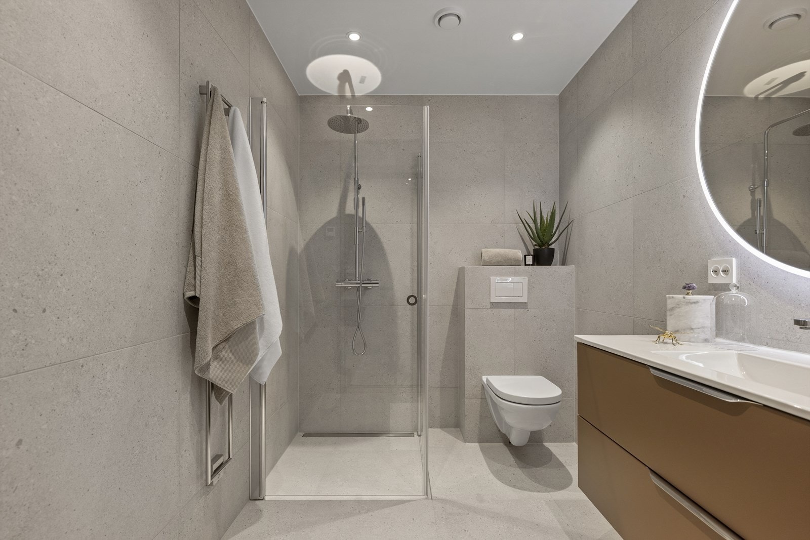 Badene er delikat flislagt med store fliser (60 x 120), har varme i gulv og downlights i himling Galleribilde