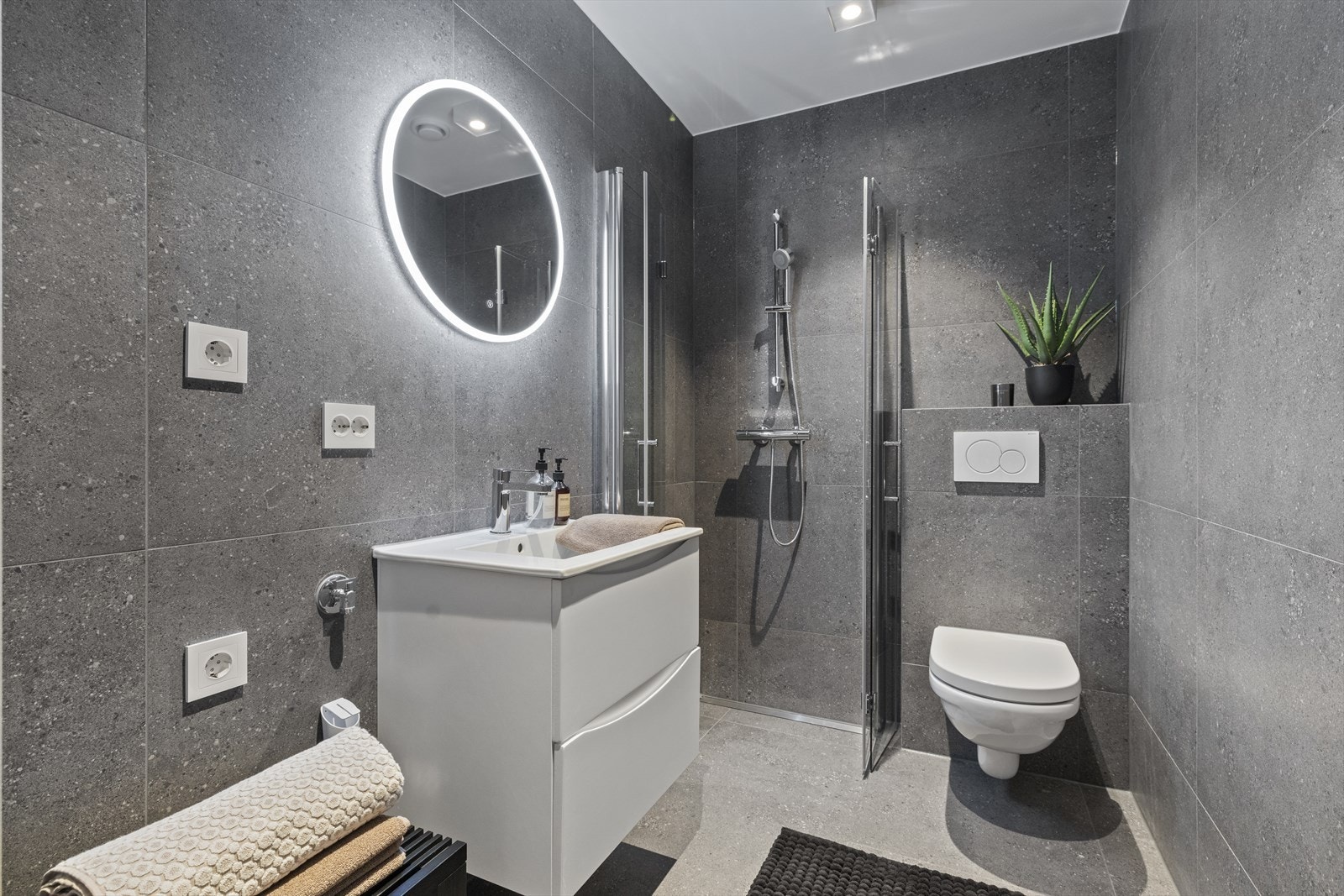 Badene er utstyrt med innbygningssisterner, speil med lys og anti-dugg-funksjon - detaljer som gir både komfort og et stilrent uttrykk -Det er opplegg for vaskemaskin Galleribilde