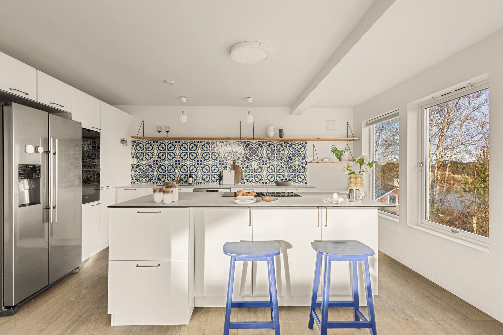 Lekkert kjøkken med sosial øy, god med skap- og benkeplass og integrerte hvitevarer Galleribilde