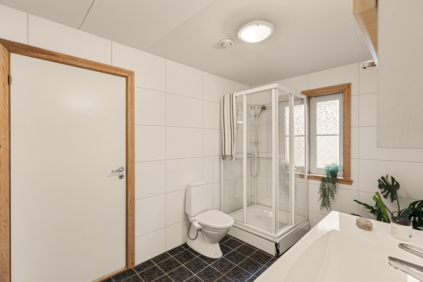 Rommet inneholder innredning med servant, dusjkabinett, toalett, speil og belysning Galleribilde