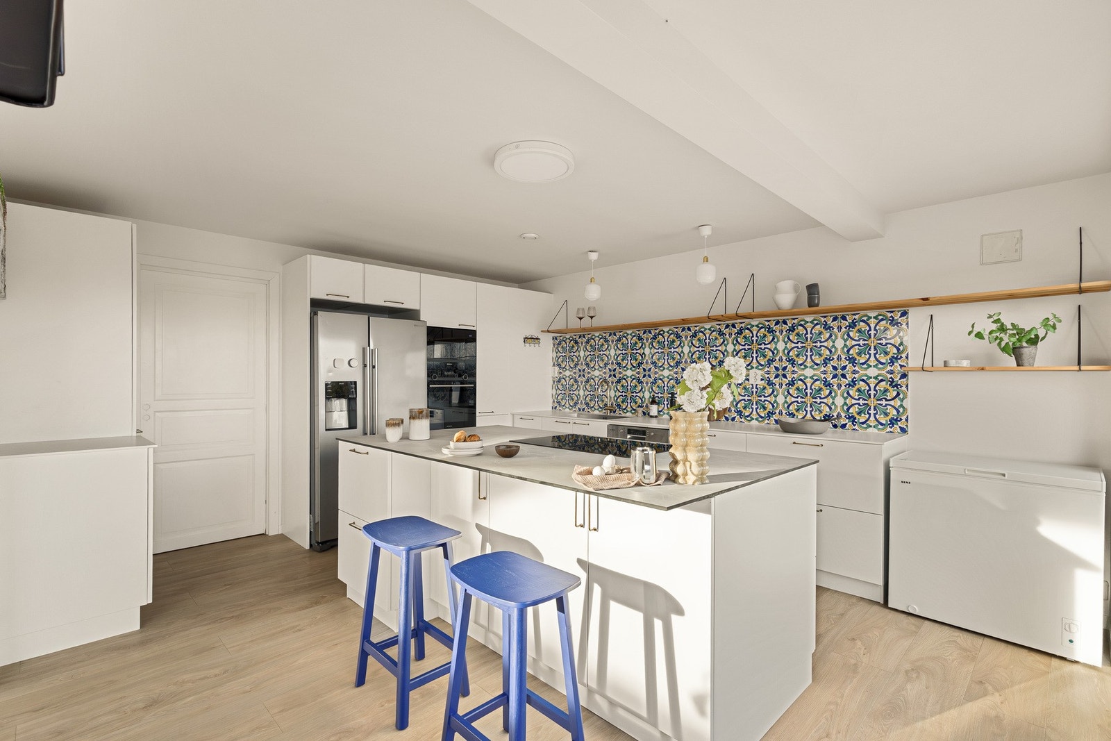 Åpen løsning mellom stue og kjøkken gir boligen et sosialt preg Galleribilde