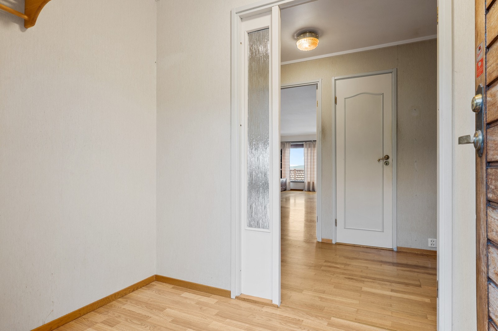 Inngangspartiet har en ytterdør i teak og leder inn til boligens hovedetasje. Galleribilde