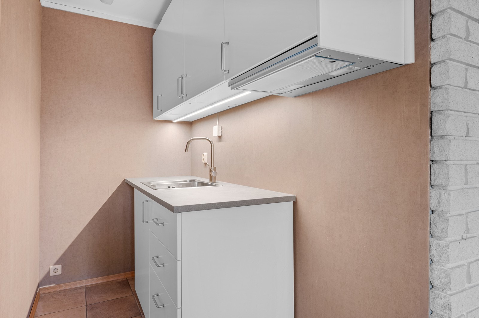 Kjøkkenkroken i hybelen har en nyere innredning med slette fronter. Det er også avsatt plass til frittstående hvitevarer. Galleribilde