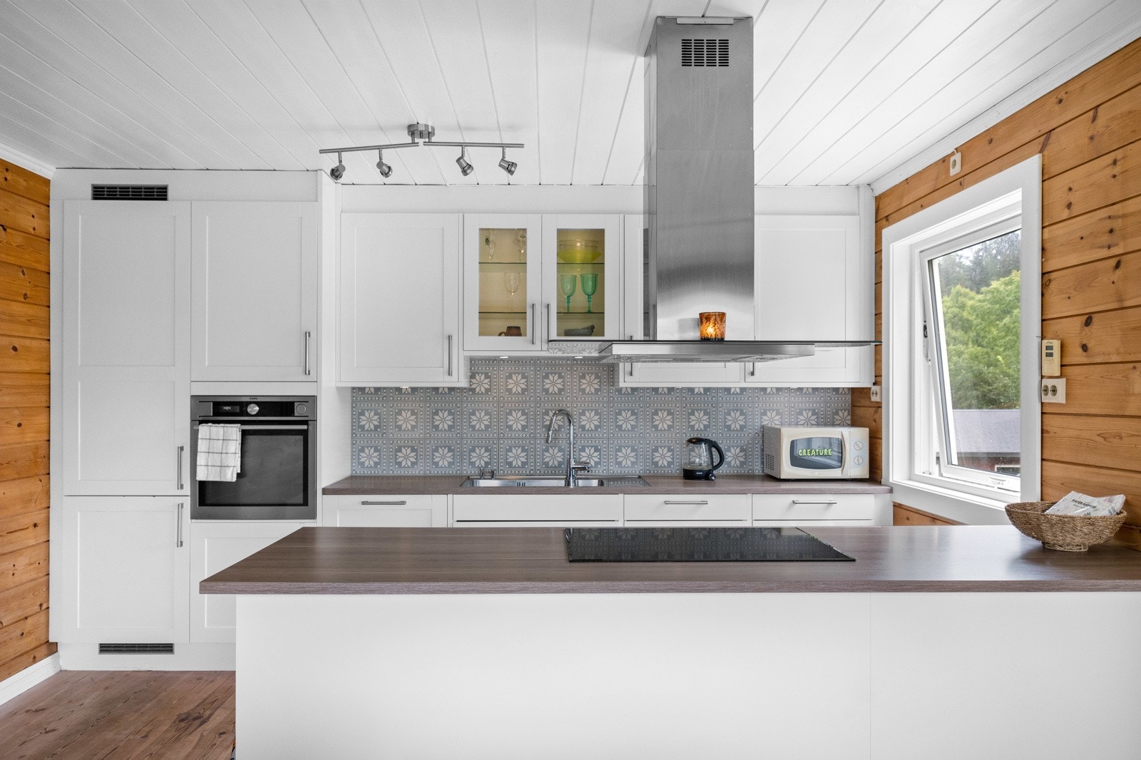 Over oppvaskkummen er det fine fliser, og hvitevarer som stekeovn, oppvaskmaskin og kjøl/frys er integrert. Galleribilde