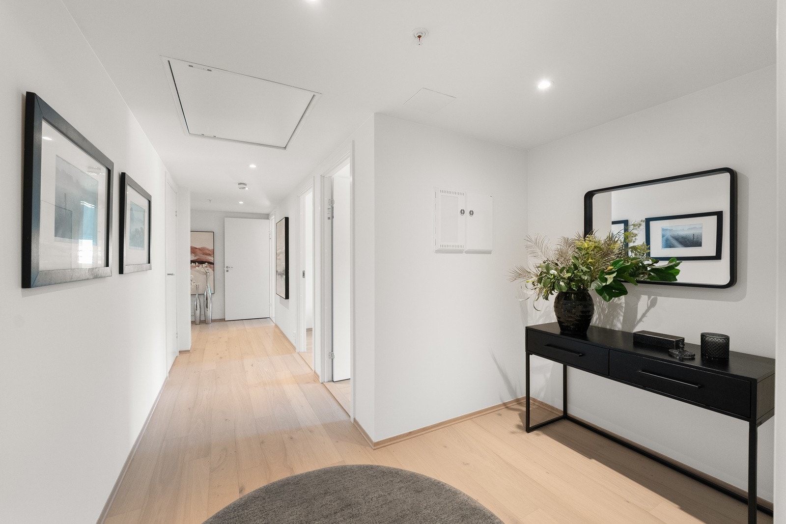 Inngangspartiet gir et solid førsteinntrykk med sin moderne estetikk, enstavsparkett på gulvet og lyse fine vegger som reflekterer den generelle stilen i boligen. Galleribilde