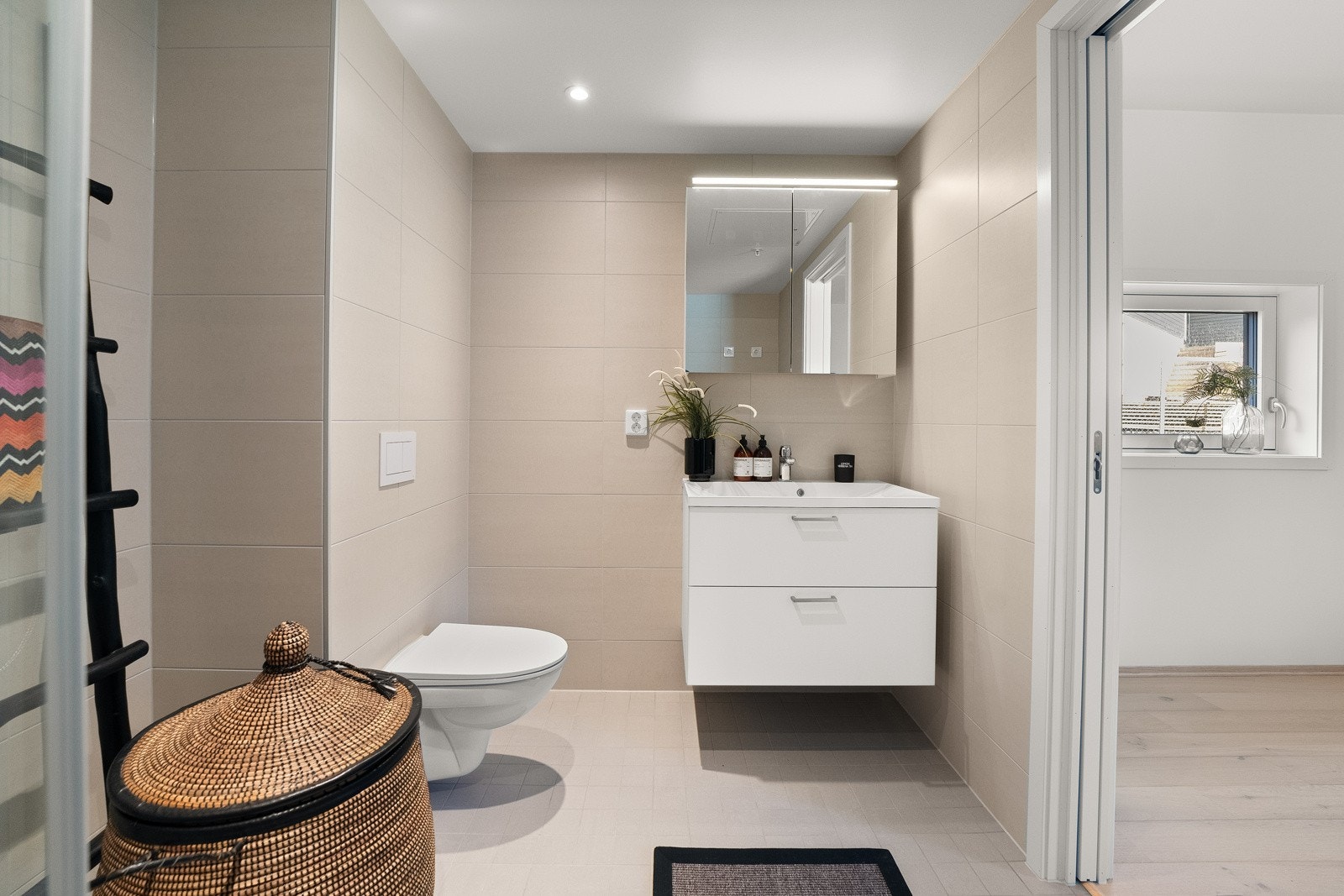 Badene i leiligheten er flislagte og gir et moderne utttrykk med sin lyse fargepalett. Galleribilde