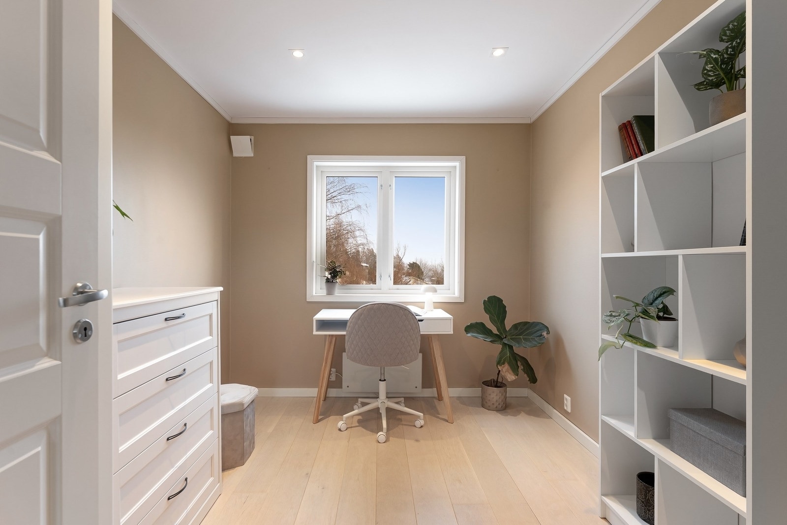 Rommet har plass til skrivepult og oppbevaring, med utsikt fra vinduet. Galleribilde