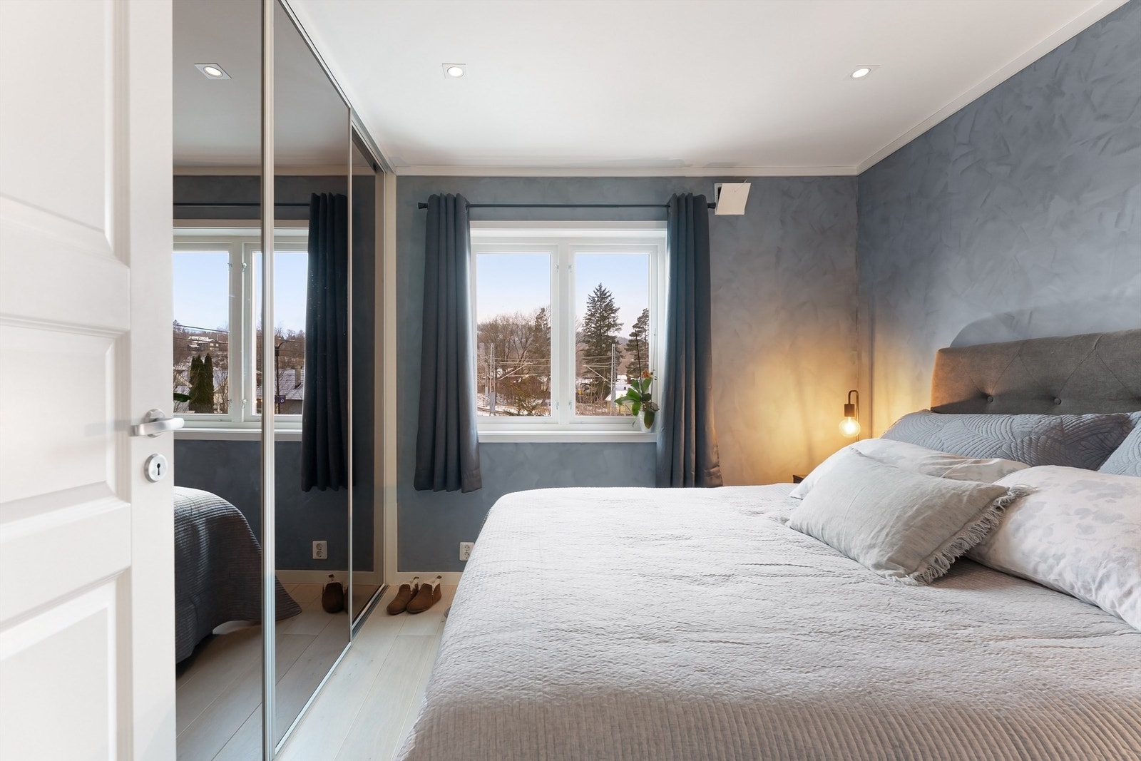 En stor skyvedørsgarderobe med speilfronter gir rikelig med oppbevaringsplass. Galleribilde