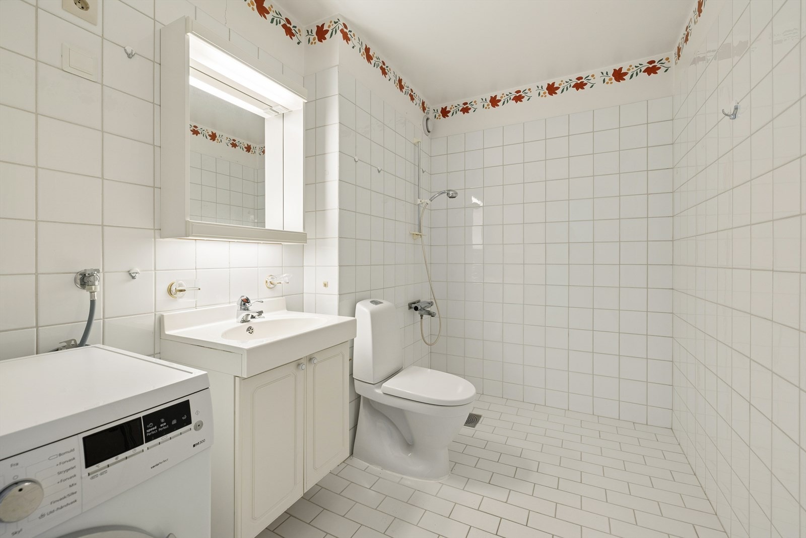 Flislagt baderom med gulvvarme. Innredning med nedfelt servant, toalett, dusjvegger/hjørne og opplegg for vaskemaskin. Galleribilde