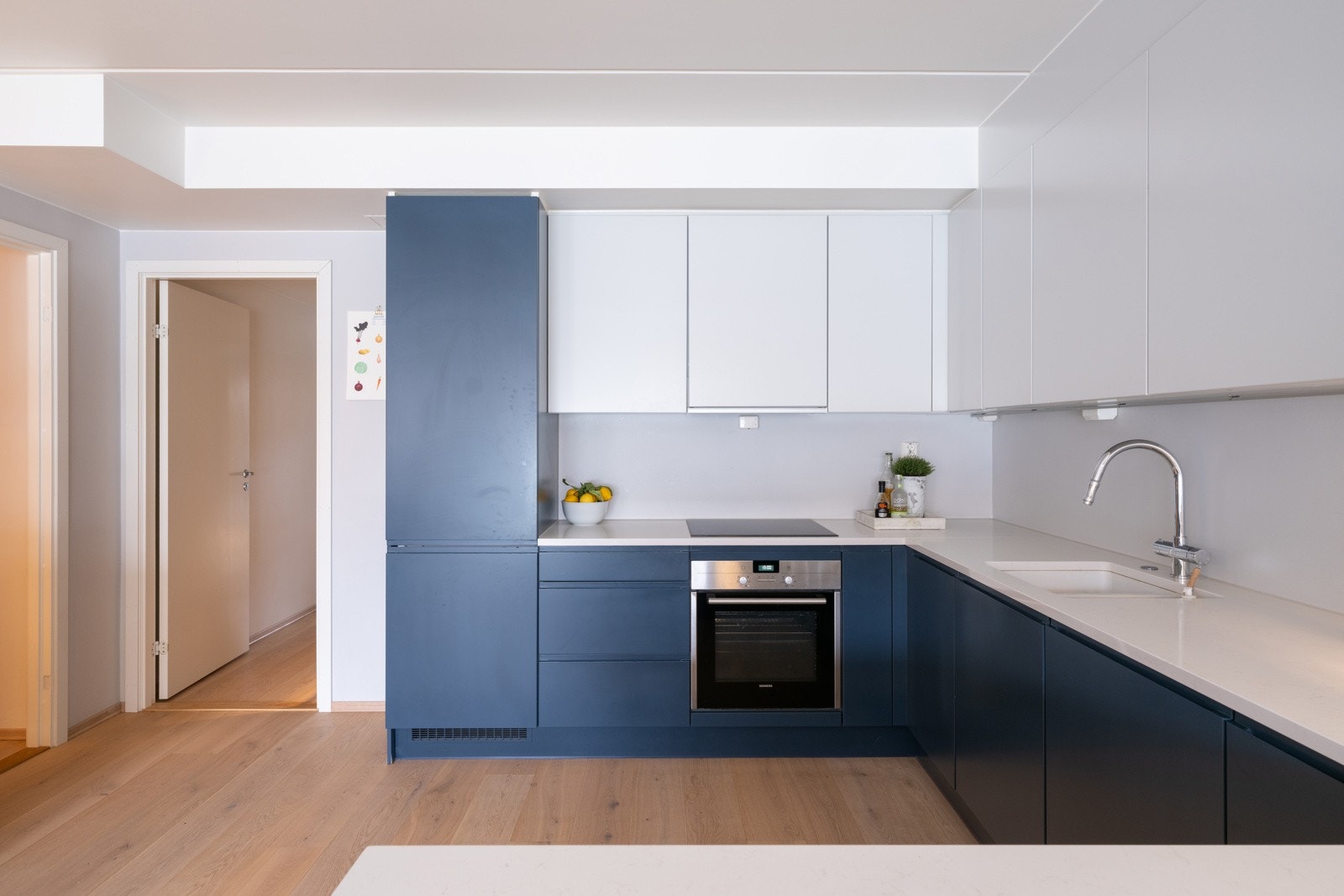 Kjøkkenet har pene fronter og benkeplate i steinkompositt med underlimt kum i kompositt/plast, samt praktisk LED-belysning under overskap. Galleribilde