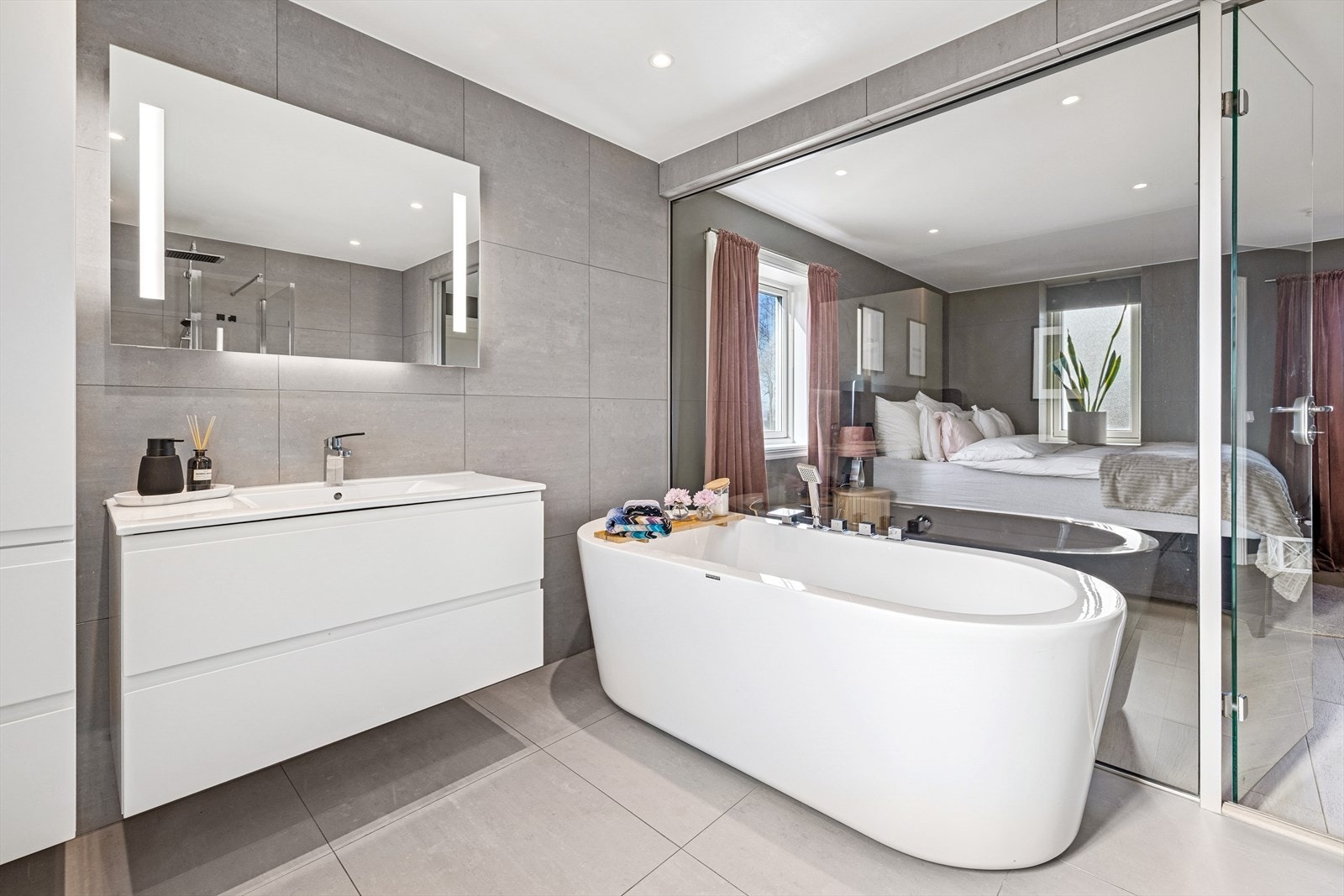 Det er satt opp en stor glassvegg mellom soverommet og badet som gir rommet et unikt særpreg. Galleribilde