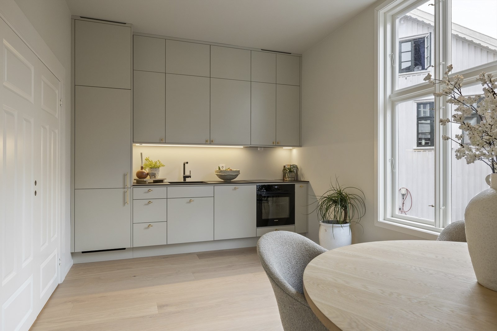 Kjøkkenet er designet med tanke på maksimal utnyttelse av rommet, og skapene strekker seg helt opp til taket for å gi deg rikelig med oppbevaringsplass og et helhetlig uttrykk. Galleribilde