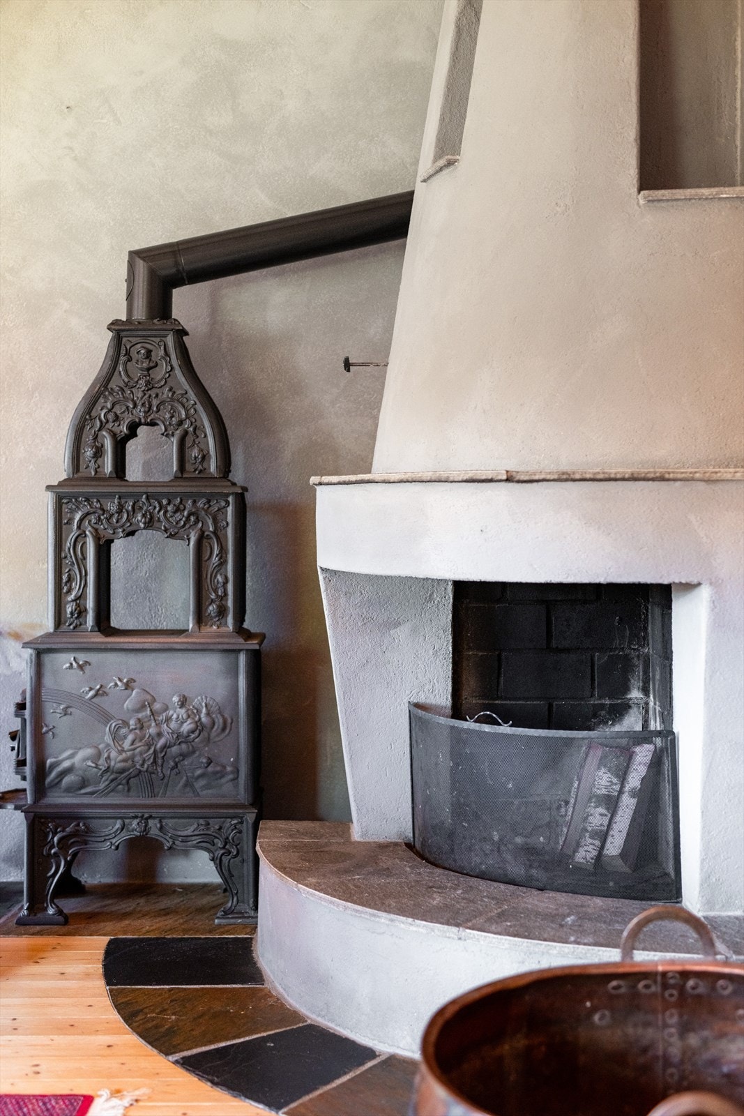 Stua har både åpen stemningsfull peis og etasjeovn med vakre detaljer for god og lun varme på kalde dager. Galleribilde