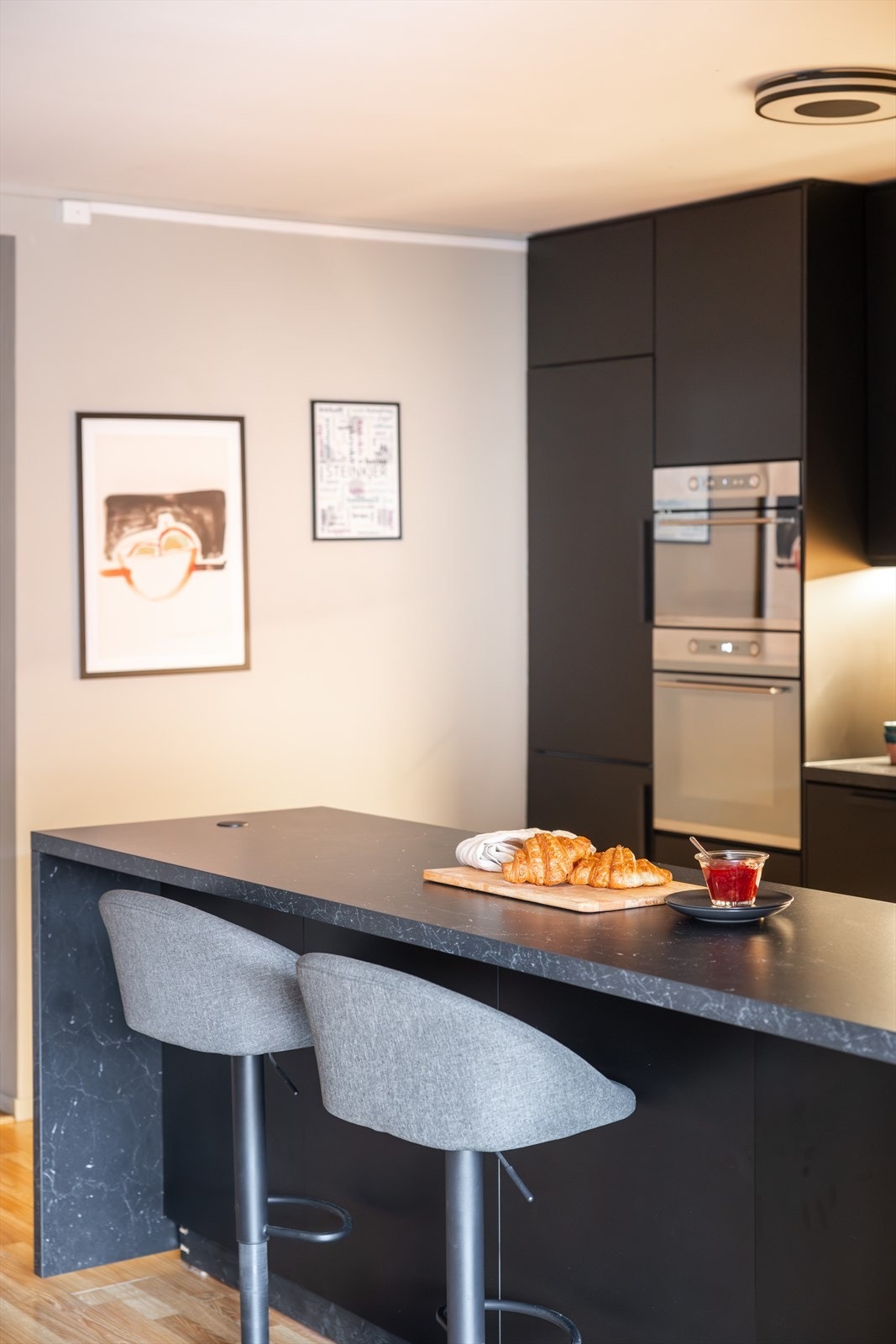 En sosial kjøkkenøy med barløsning gjør det enkelt å underholde gjester under matlagingen Galleribilde