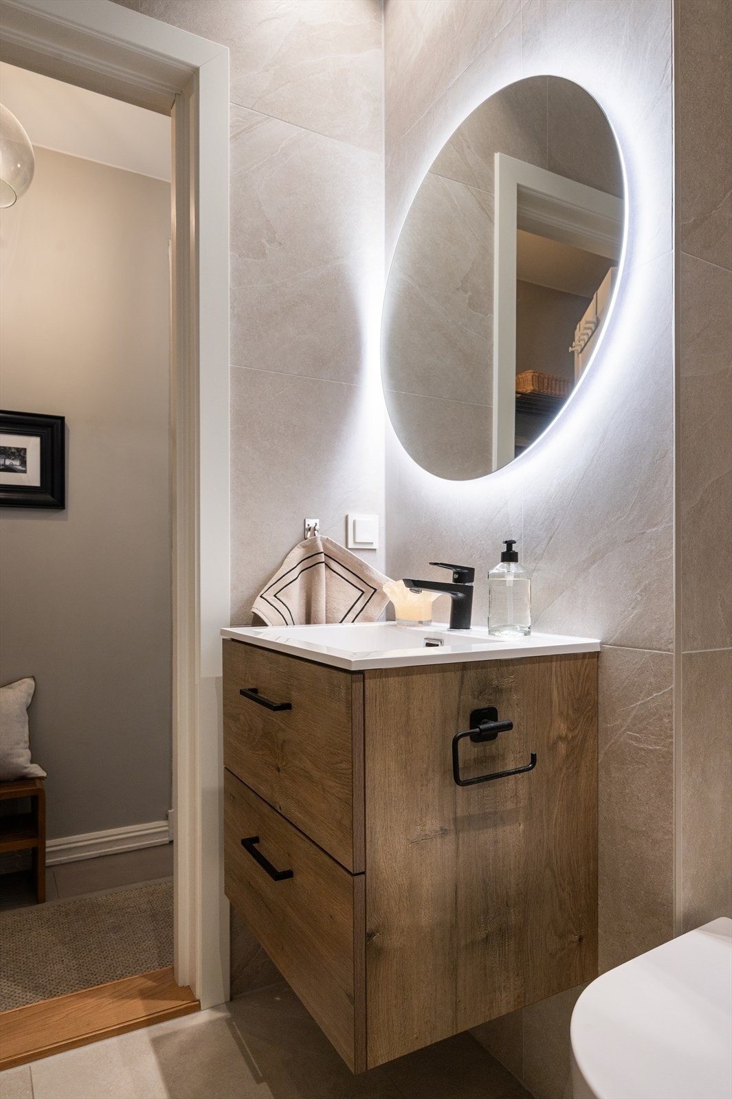 Rommet er innredet med vegghengt klosett, servant nedfelt i innredning, speil og dusjhjørne med svingbare glassdører. Galleribilde