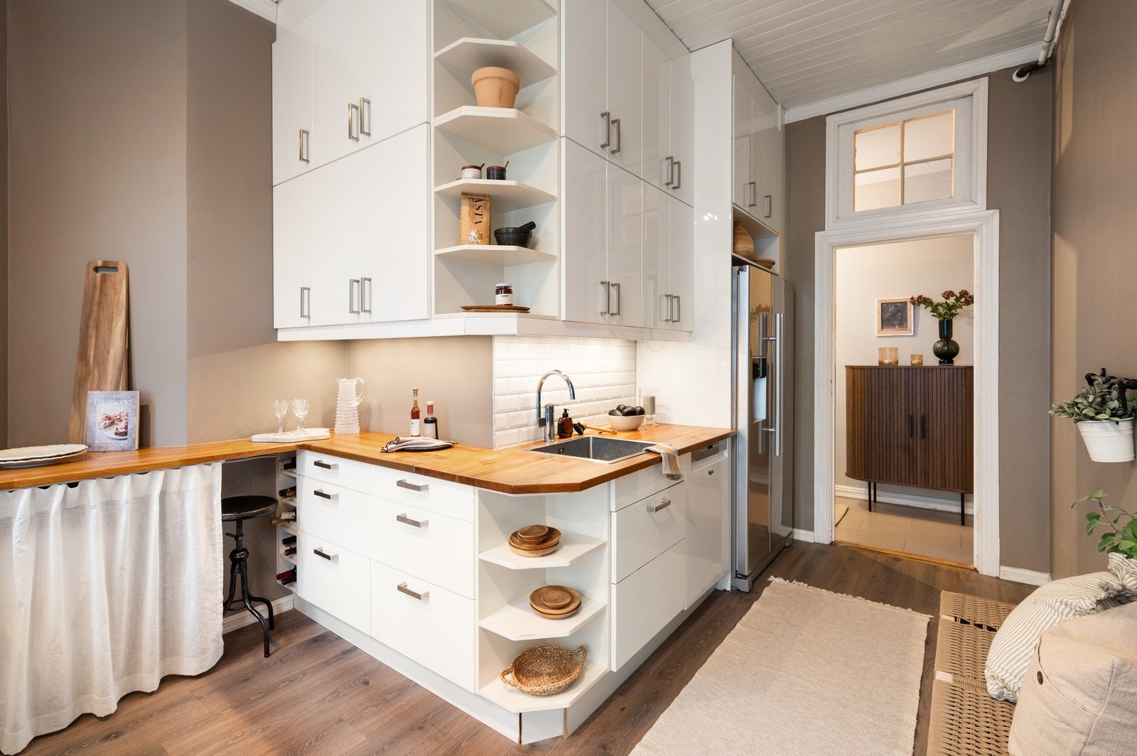 Den gode benkeplassen gjør matlagingen enkel. Kjøkkenet har en moderne innredning med glatte fronter og en solid heltre benkeplate med nedfelt vaskekum. Galleribilde