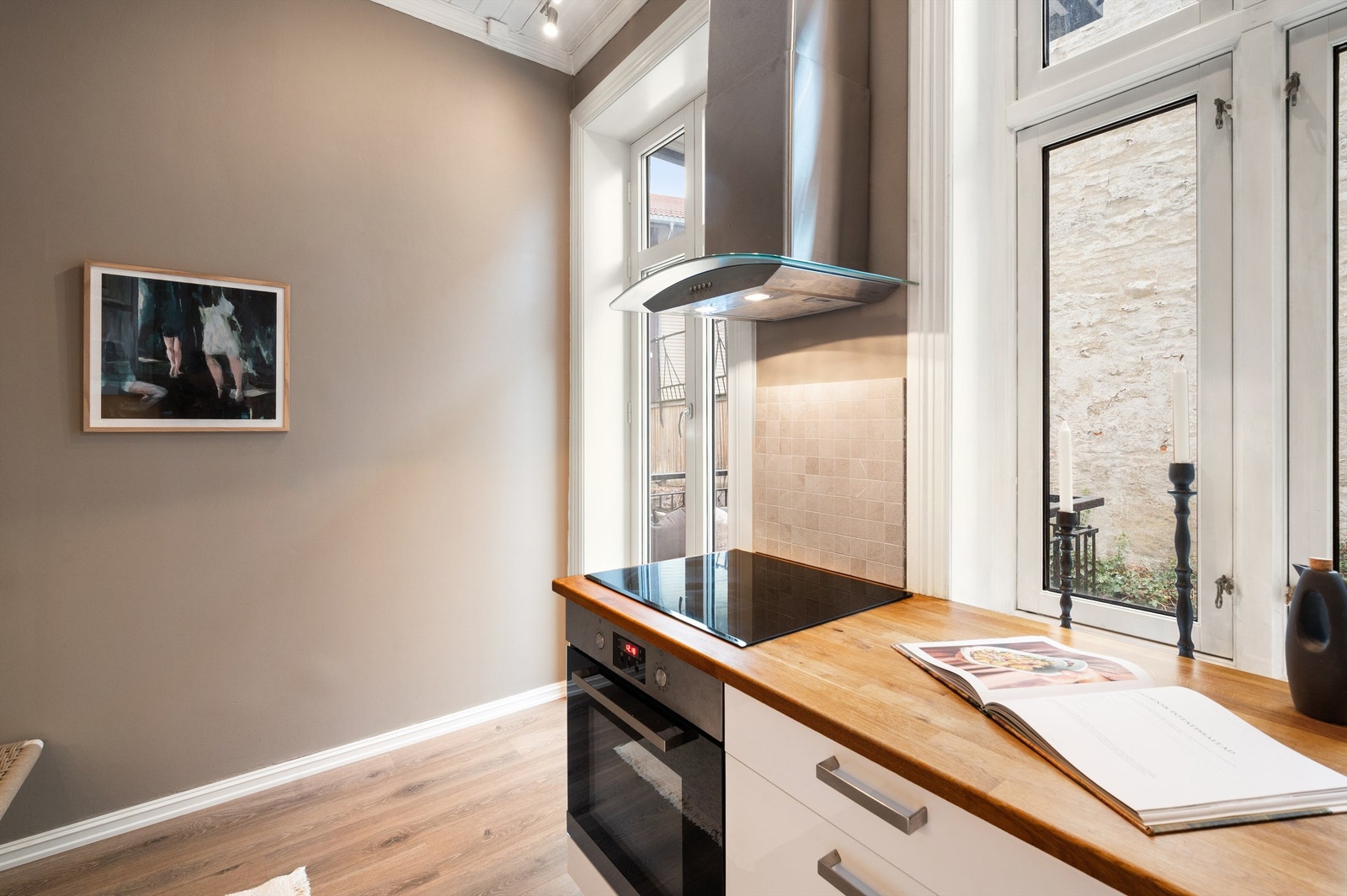 Induksjonstopp, stekeovn og oppvaskmaskin er sømløst integrert i innredning. Fra balkongen får kjøkkenet et fint lysinnslipp. Galleribilde