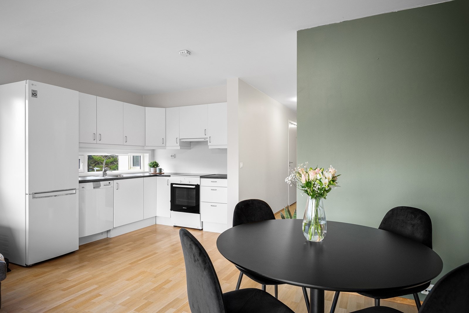 Innredningen er utstyrt med glatte, hvite fronter og har en benkeplate av laminat. Galleribilde