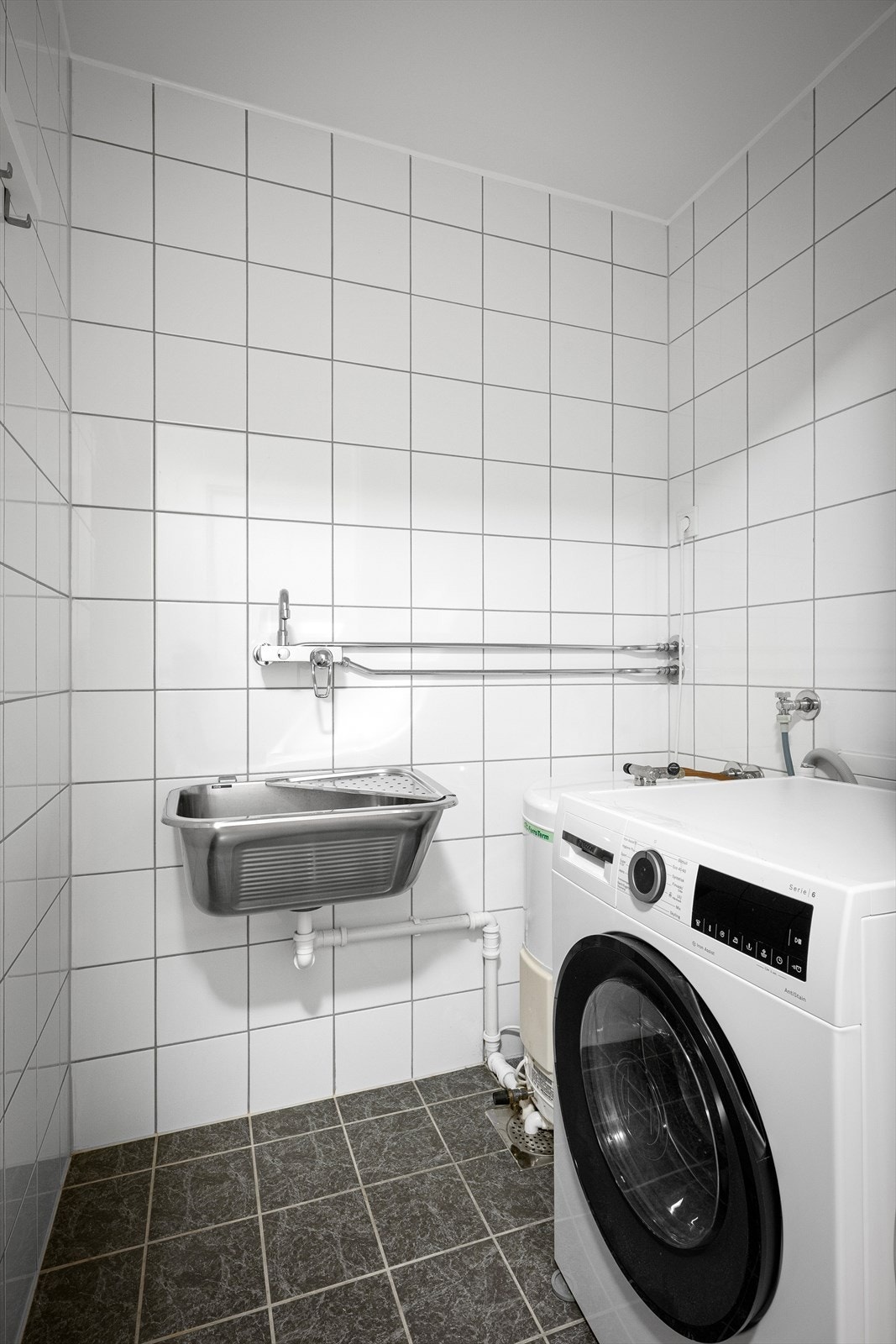 Vegg i vegg med badet ligger et praktisk vaskerom. Galleribilde