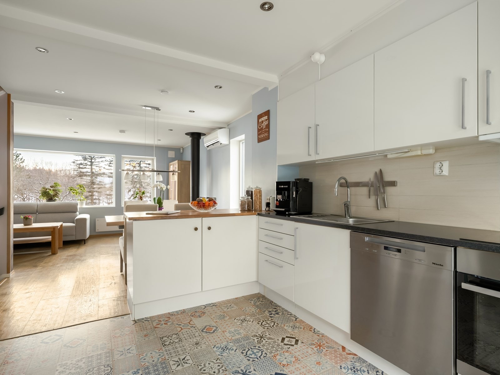 HTH-kjøkkenet fra 2012 er med lyse og slette fronter, det er fliser over benkeplate og belegg på gulvet. Galleribilde