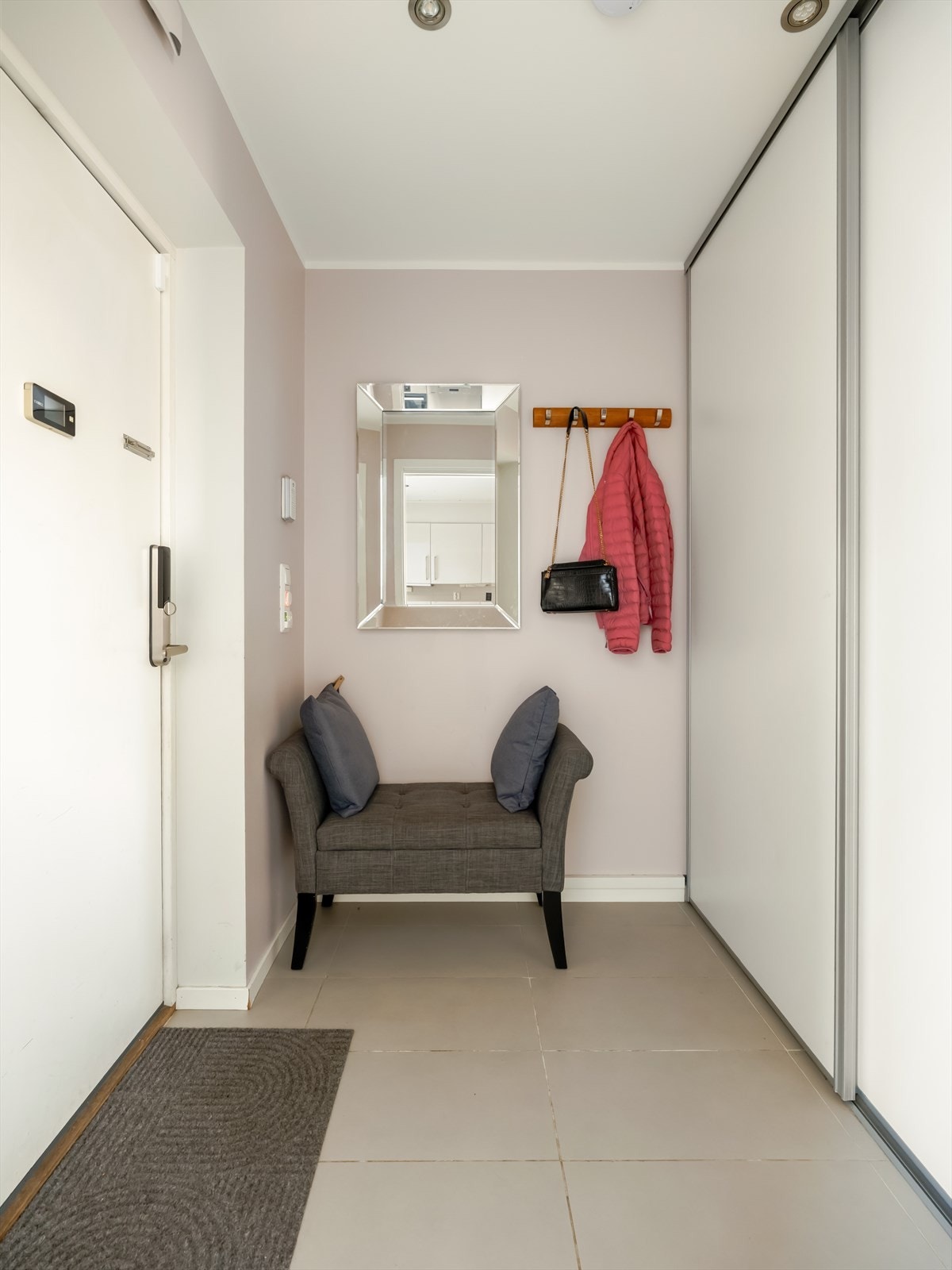 Entréen er flislagt og lys, og det er gode muligheter for å henge fra seg yttertøy og sko i plassbygd garderobeskap med skyvedører. Galleribilde