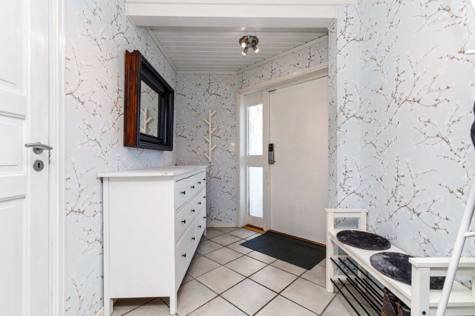 Her blir du tatt imot i en flislagt
og lys entré med god plass til å sette fra deg sko,
og henge fra deg yttertøy. Galleribilde