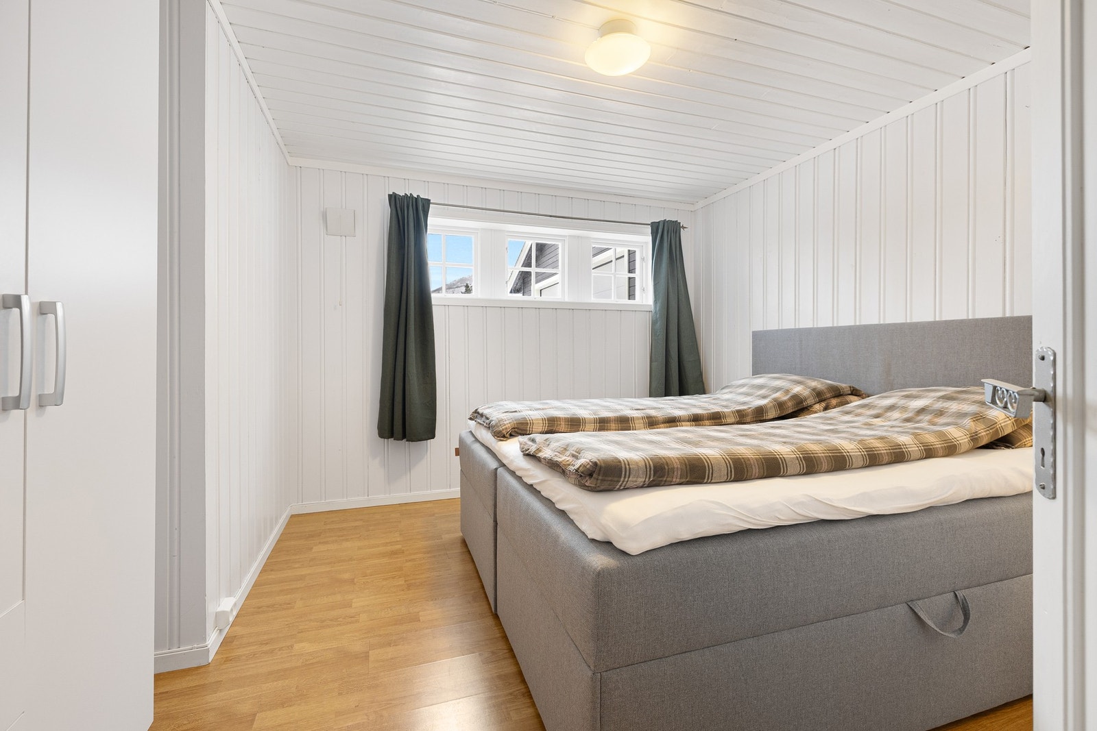 Kjelleretasjen har romslige og funksjonelle soverom med lys og trivelig utforming. Rommene har panelkledde vegger og himling, samt varierende gulvbelegg som gir et lunt preg. Vinduer gir naturlig lys og bidrar til en behagelig romfølelse. Soverom 4. Galleribilde