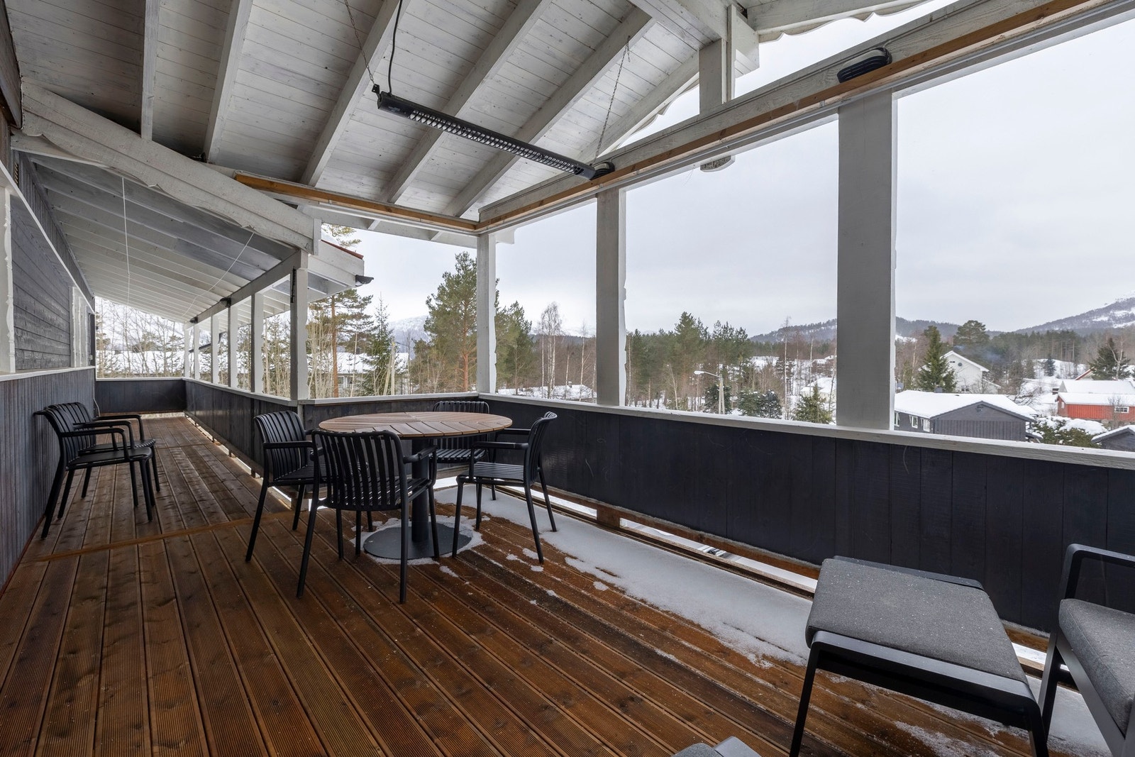 Romslig, overbygd veranda som strekker seg langs fasaden og gir gode sol- og oppholdsforhold. Galleribilde