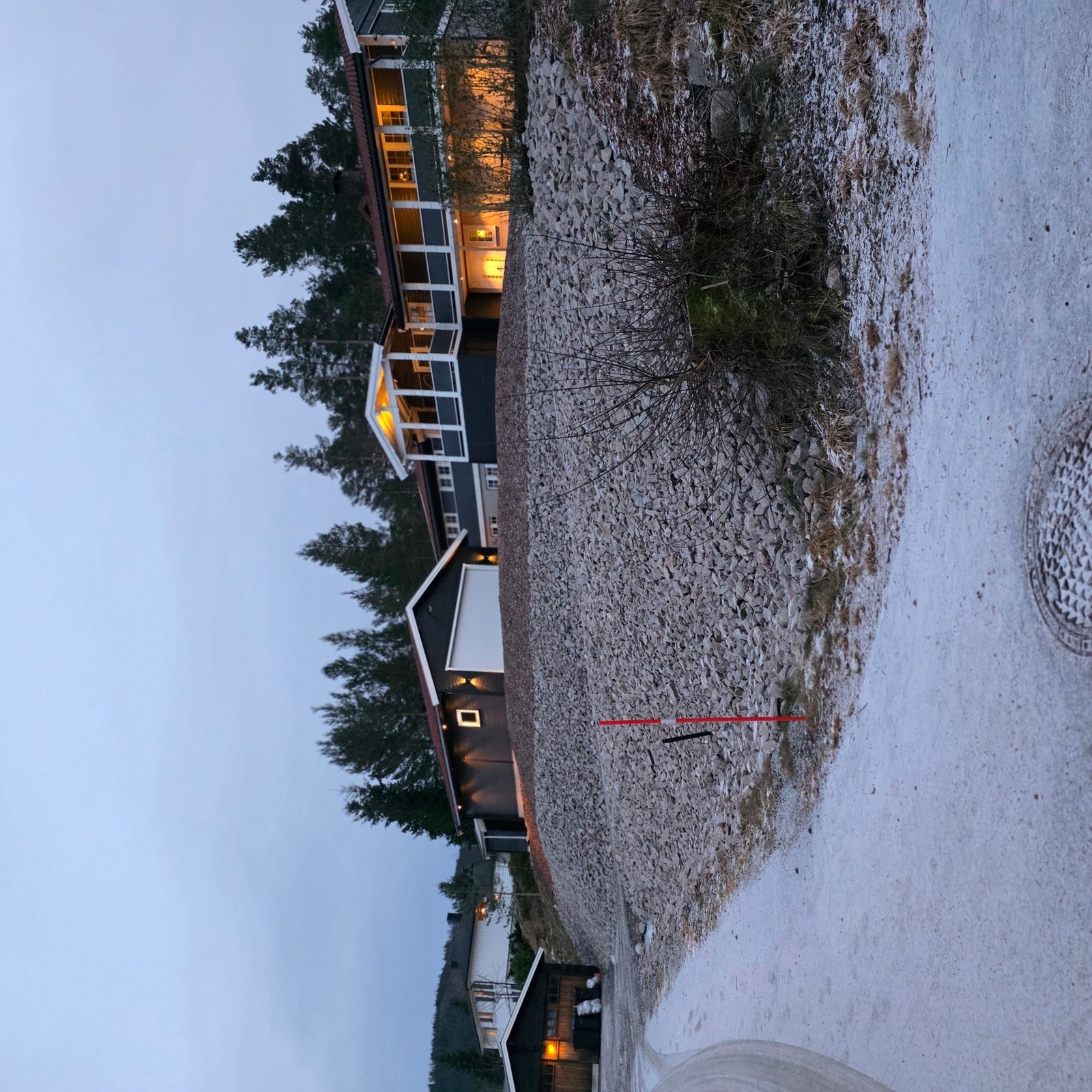 Eiendommen sett fra vei, med solid garasje og pent opparbeidet gårdsplass. Galleribilde