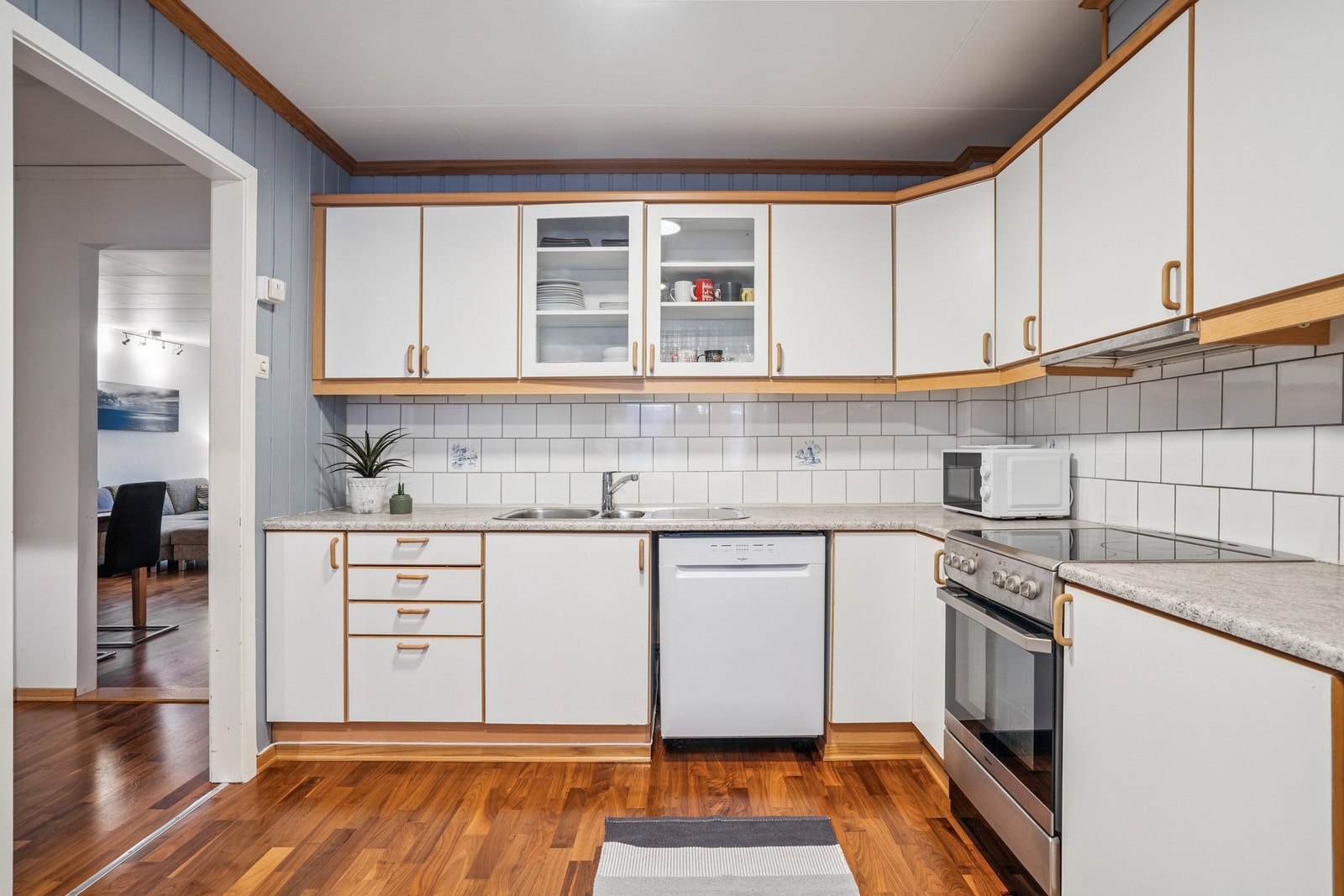 Lyst og praktisk kjøkken i eget rom, med en innholdsrik og funksjonell innredning som gir godt med skap- og benkeplass. Galleribilde