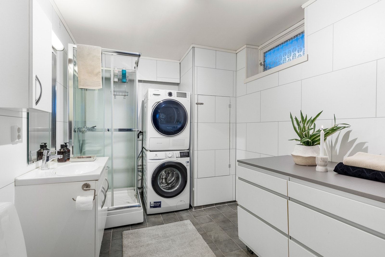 Praktisk bad/vaskerom med opplegg for vaskemaskin og tørketrommel. Galleribilde