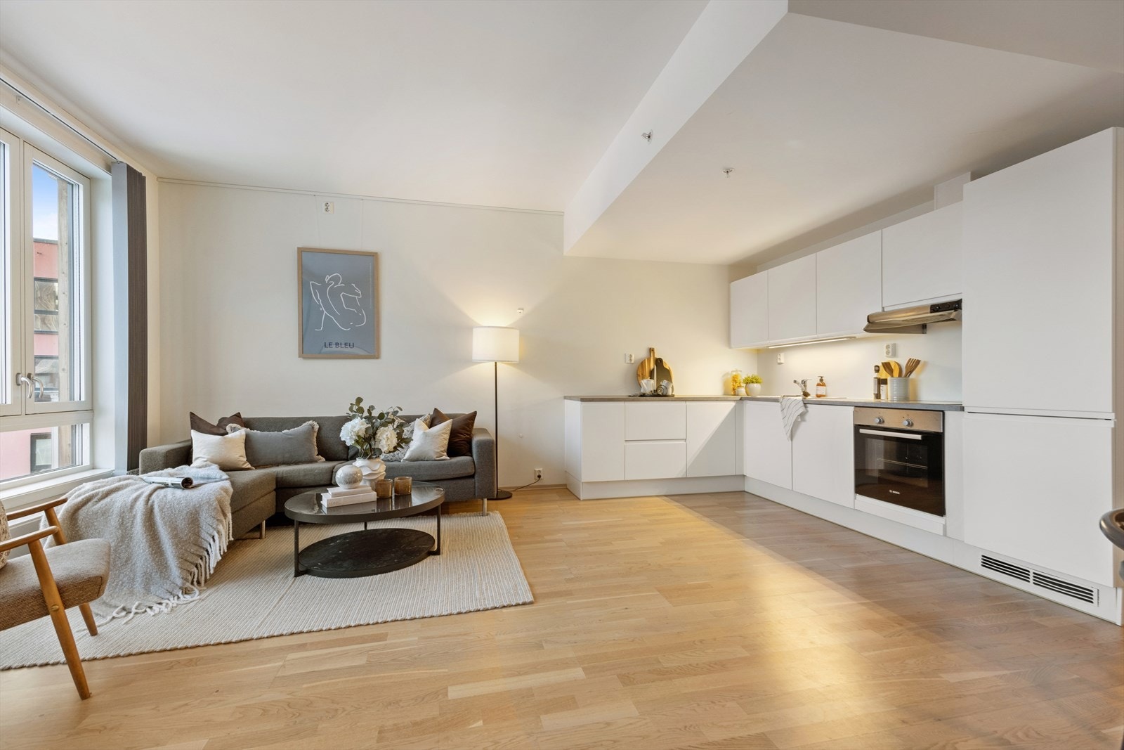 En stilren kjøkkeninnredning med glatte, hvite fronter og laminat benkeplate. Galleribilde