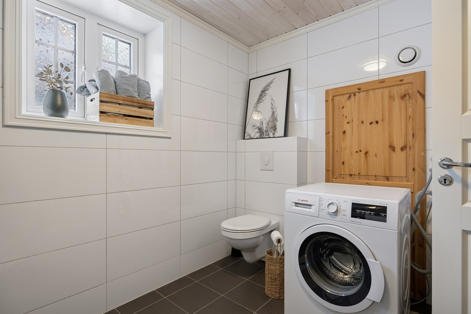 Sanitærutstyr inkluderer dobbel servant, dusjkabinett og vegghengt toalett. I tillegg er det opplegg for vaskemaskin Galleribilde